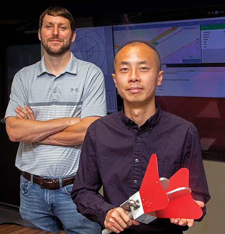 Victor Murray and Jimmy Li standing in front of projector screens