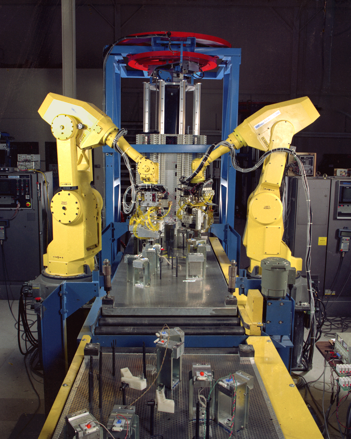 Two yellow robotic arms building components